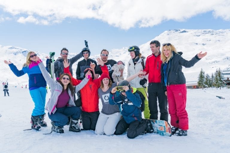 A group of guests with Richmond Christian holidays smiling in the snow and holding their ski equipment