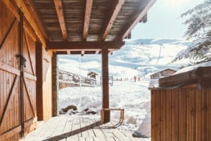 Looking out from the Richmond holidays ski chalet terrace onto the snowy piste with skiers