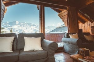 Sofas in Chalet des Neiges, looking out over the snowy ski slopes in winter