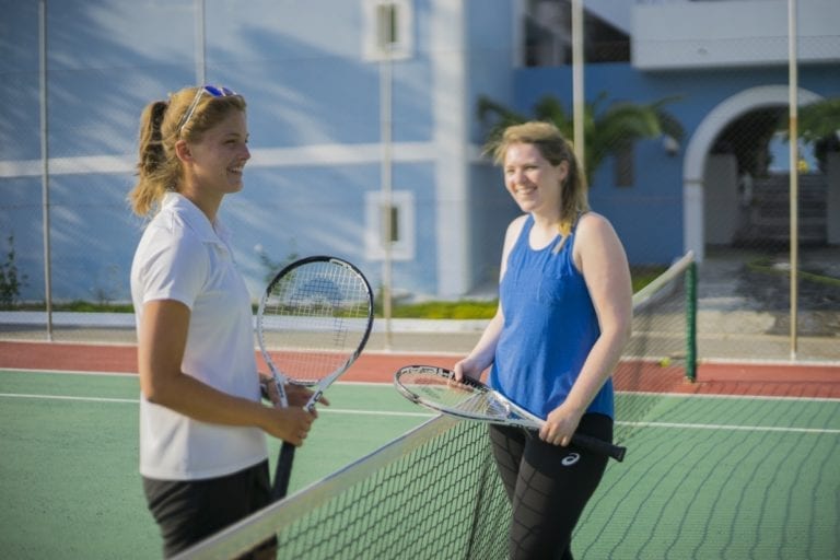 Guests and staff playing tennis on a summer holiday in Samos, Greece