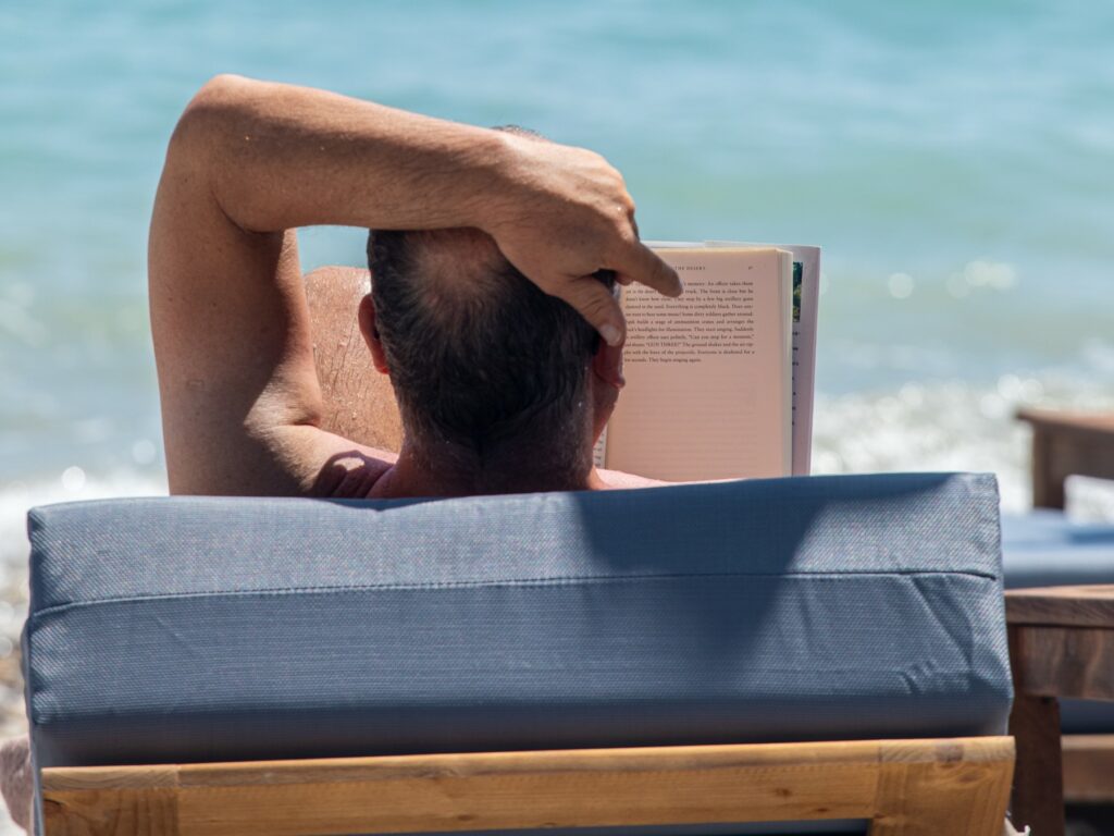 Guest reading their book on the beach relaxing