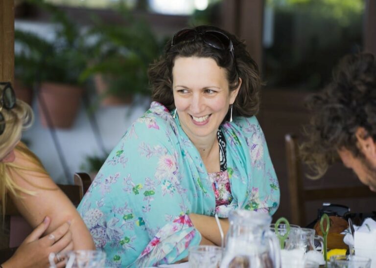 A lady smiling whilst sharing a meal whilst on holiday in Samos, Greece