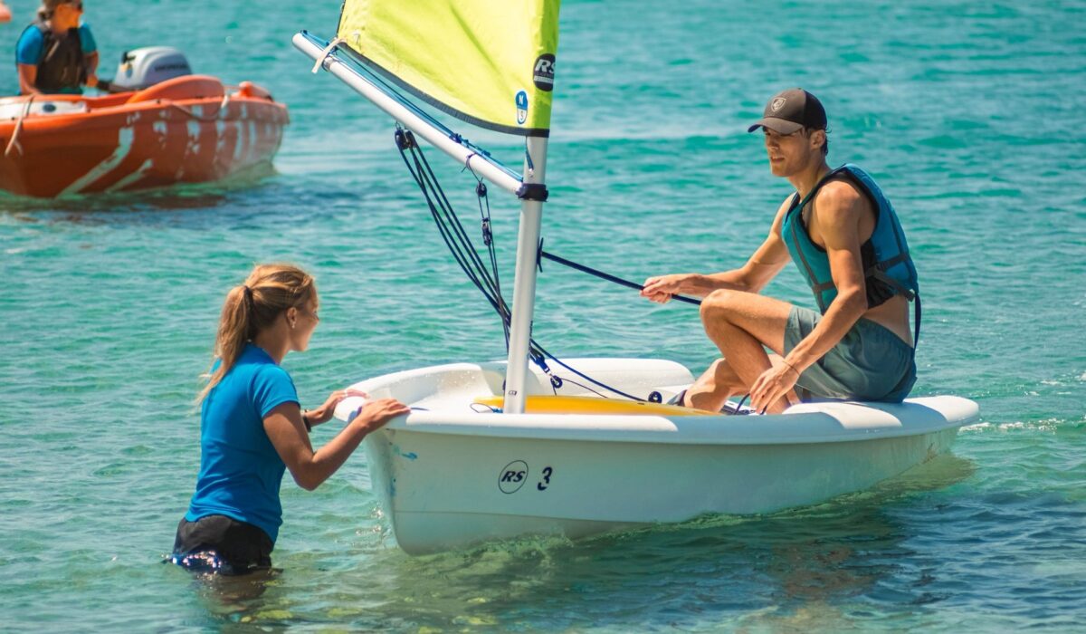 Young man sailing with the help of a Richmond Holidays staff member