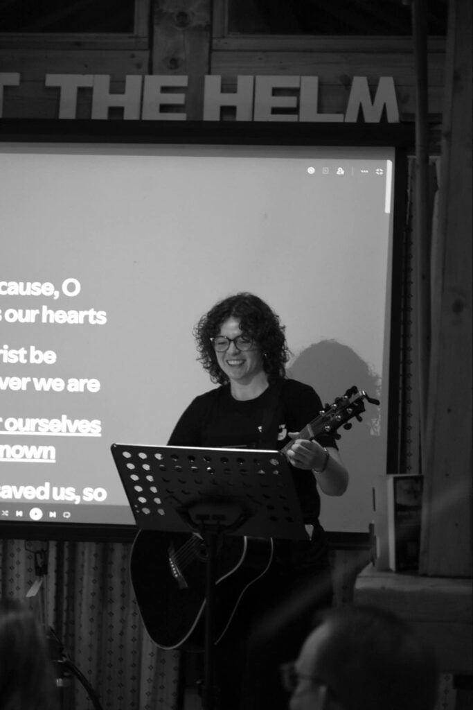 Worship leader holding a guitar and singing to Richmond guests on holiday