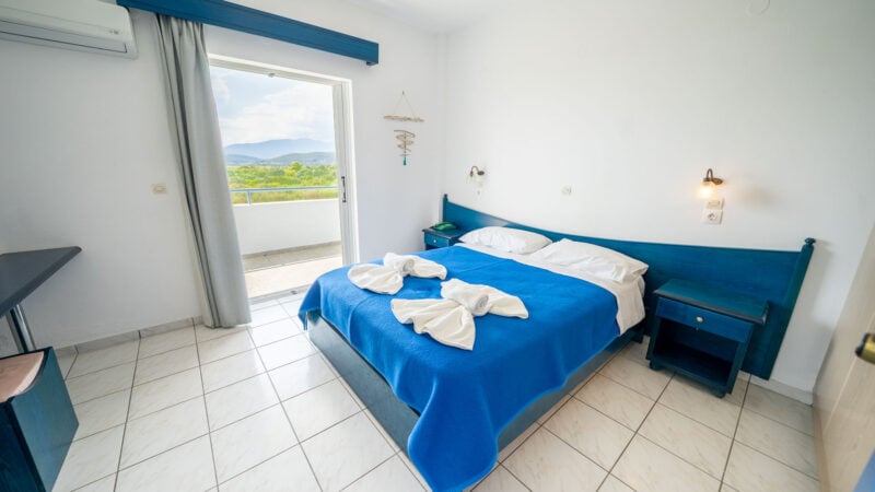 Corner Suite room with double bed and balcony with sea views.