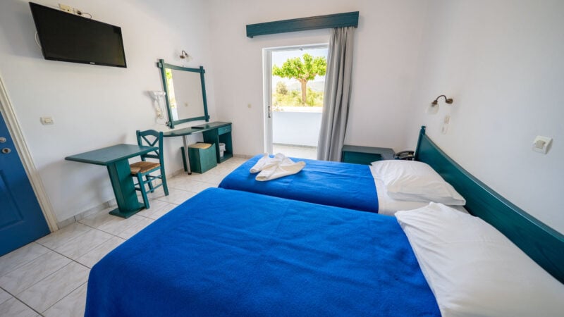 A Lower-Level Room with two twin beds and a private patio with garden views.