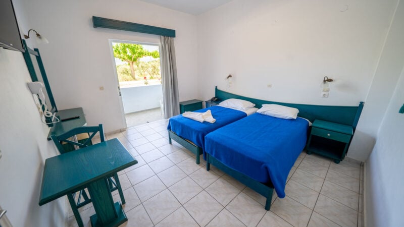 A Lower-Level Room with two twin beds and a private patio with garden views.