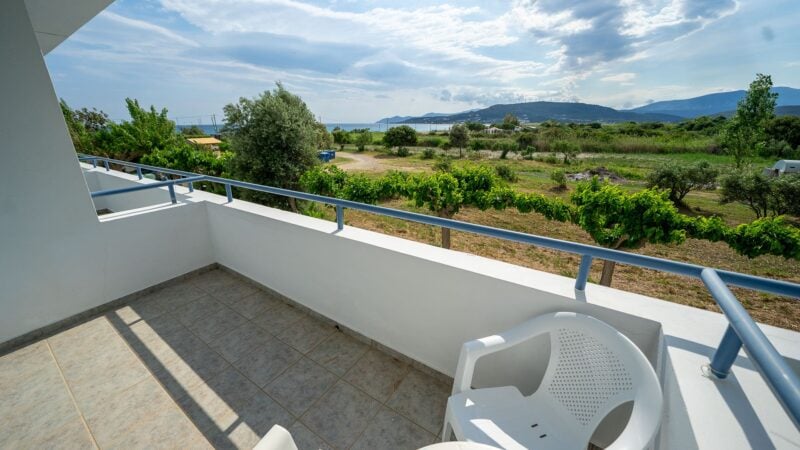 Reception Level balcony with white plastic table and chairs and sea views.