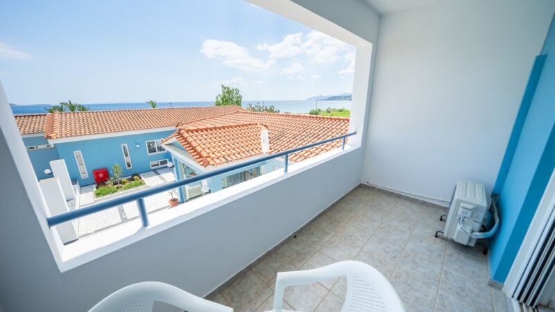 An Upper-Level Room balcony with two white plastic chairs which overlooks the top of the hotel.