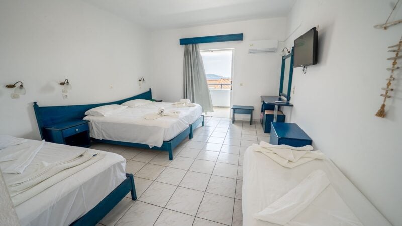 An Upper-Level Room with four twin beds in total. Flatscreen TV on the wall and balcony with views of the sea.