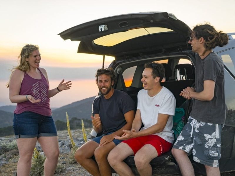 Friends laughing and chatting on a road trip around Samos, Greece