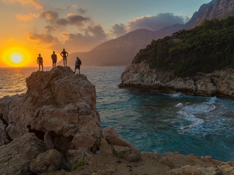 Friends enjoying a beautiful summer sunset over the Aegean Sea in Samos, Greece