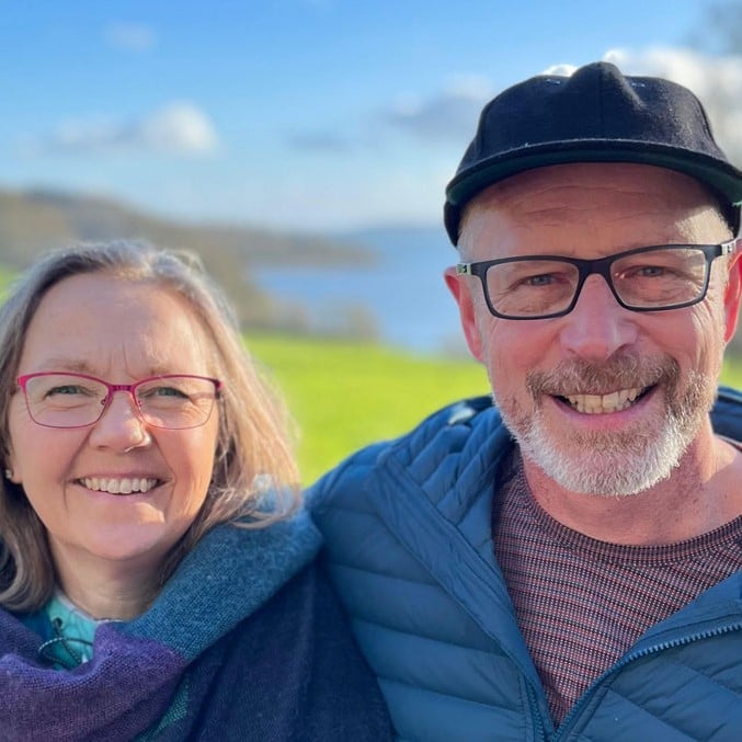 Matthew and Grace standing next to each other in the countryside smiling